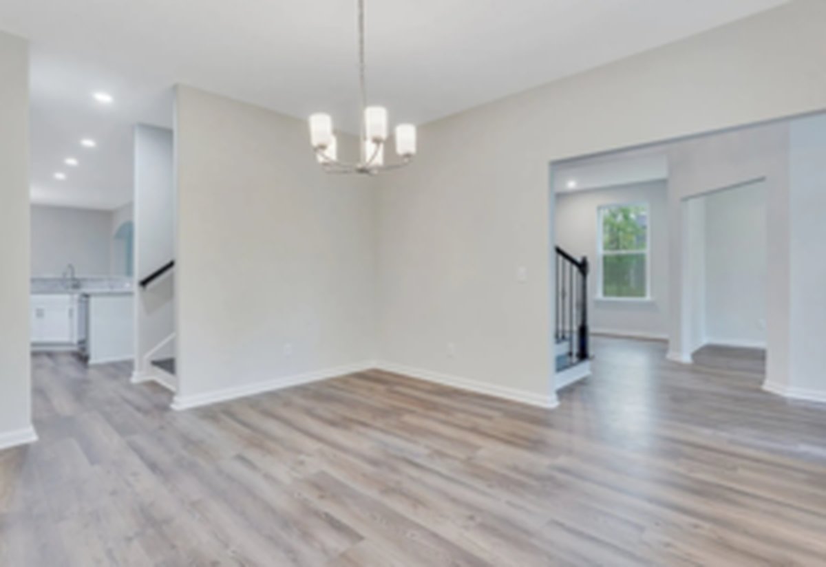 Formal dining room at the front of the home with a coffered ceiling and large front-facing windows