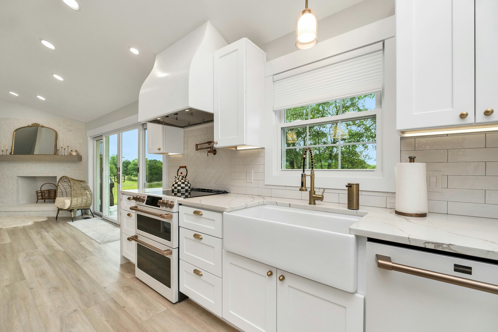Bright new-construction kitchen with white cabinetry, marble-look counters, and stainless appliances